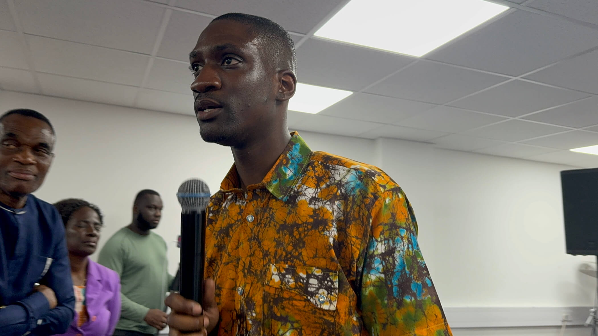 Pastor Sam holding mic